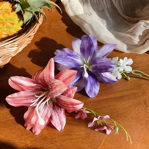 Dettaglio ravvicinato di fermagli per capelli a forma di giglio artificiale viola e corallo.