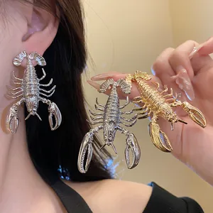 Detailed view of statement metallic lobster earrings in gold and silver finishes.