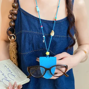 Detail view of a bright blue leather sunglass holder necklace with starfish and star charms