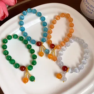Detail view of four colorful cat's eye stone bracelets displayed on a white plate.