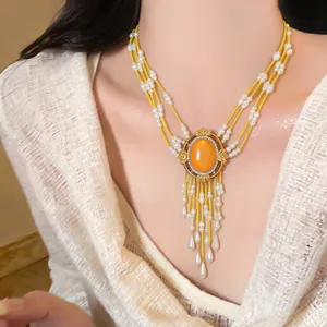 Detailansicht einer eleganten, mehrlagigen Perlenkette mit orangefarbenem Mittelstein