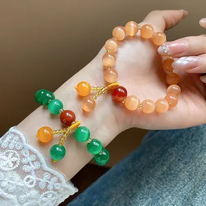 Detailed view of elegant cat-eye stone beaded bracelets in vibrant peach and green