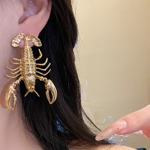 Detailed macro view showing a vintage gold-toned metal lobster earring worn on ear.