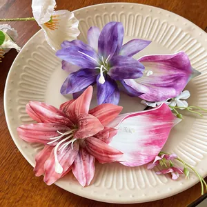 Vista dettagliata di fermagli per capelli con fiori artificiali rosa e viola su un piatto.