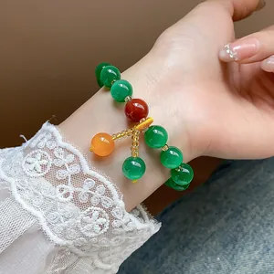 Detailed view of cat's eye stone beaded bracelet worn on wrist with lace cuff