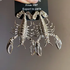 Detailed view of vintage silver-tone metal lobster earrings with intricate textures.