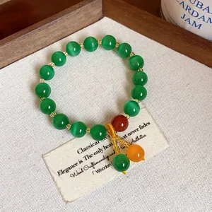Detailed view of an elegant vintage cat's eye stone beaded bracelet with vibrant green hues.