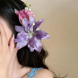 Dettaglio ravvicinato di un fermaglio per capelli con giglio viola e calla rosa