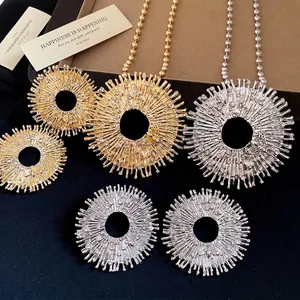 Elegant sunburst circle pendant necklace with diamond bee detail in gold and silver.
