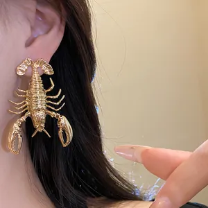 Detailed close-up of retro exaggerated golden lobster-shaped stud earrings on ear
