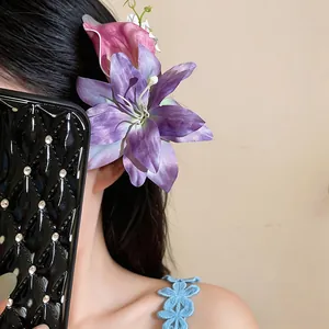 Dettaglio di un fermaglio per capelli a giglio viola artificiale indossato su capelli lunghi