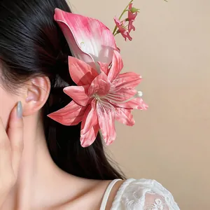 Primo piano di un fermaglio per capelli a fiore artificiale di giglio rosa su una modella.