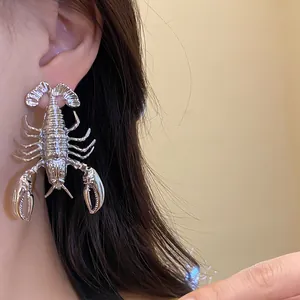 Detailed macro view of an exaggerated silver metal lobster earring worn by a female model