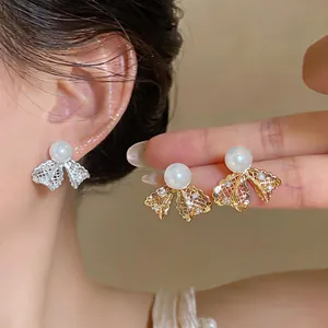 Orecchini a perno a fiocco placcati in oro 18 carati con perle e design in pizzo
