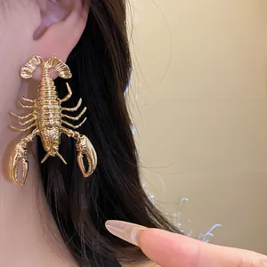 Close-up of golden metallic lobster earring showing detailed texture and realistic wear