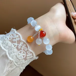 Close-up view of a retro minimalist cat's eye stone beaded bracelet worn on a female wrist