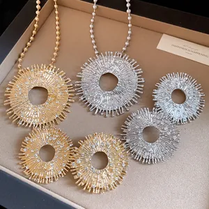 Detail view of the elegant sunburst bee pendants with sparkling crystal accents