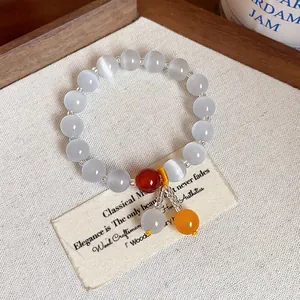 Elegant minimalist cat's eye stone beaded bracelet featuring vibrant orange accent charms