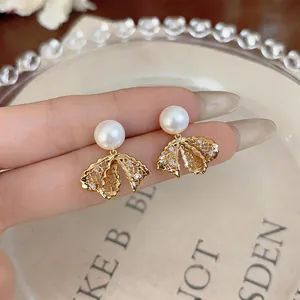 Eleganti orecchini a fiocco placcati oro con perle delicate e cristalli luccicanti