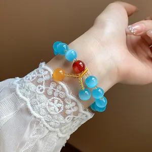 Detailed close-up showing vibrant blue cat-eye stone beaded bracelet with elegant lace sleeve