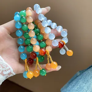 Close-up of vibrant cat eye stone beaded bracelets with elegant yellow tassels