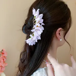 Close-up of elegant lavender fabric flower hairpin styled beautifully in a bun hair