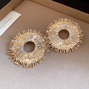 Close-up detail of luxury golden sunburst pendant featuring crystal bees and sparkling rhinestones