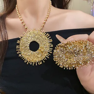Detail view of a luxury gold sunburst bee pendant necklace with sparkling rhinestones