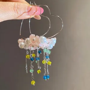 Elegant heart hoop earrings featuring pearls, pink flowers, and colorful beaded tassels.