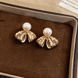 Dettaglio degli orecchini a fiocco placcati in oro 18K con perle e cristalli