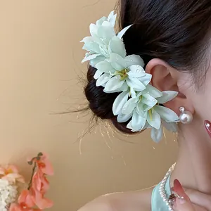 Elegant mint green fabric flower hairpin shown in detail on a model's styled hair