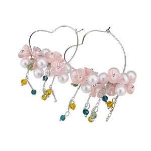 Sweet heart-shaped hoop earrings with pink flowers and pearl tassels for a resort look.
