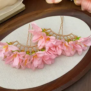 Close-up detail of pink fabric floral hairpins with delicate water drop texture