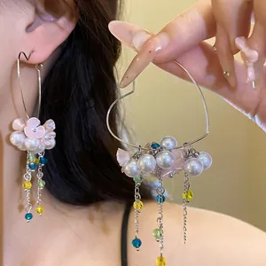 Detailed view of silver heart-shaped hoop earrings with pearls and colorful bead tassels.