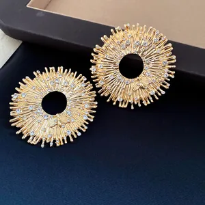 Detailed view of luxury gold-tone sunburst earrings featuring rhinestones and bee motif