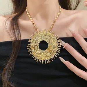 Close-up of gold sunburst pendant necklace with rhinestones and bee detail on model