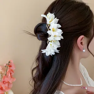 Elegant white fabric flower hair pin detail for women's traditional hair styling