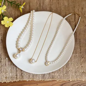 Elegant 14k gold plated pearl necklace set on white plate with rustic burlap background