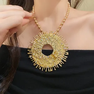 Macro detail of vintage gold round sunburst pendant with bee and rhinestone accents