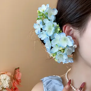 Exquisite close-up detail of light blue fabric flower hair accessory worn elegantly on head