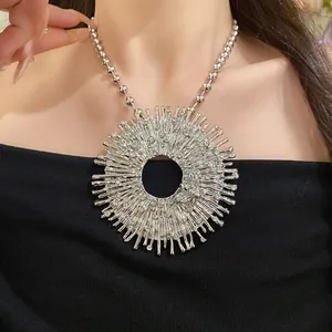 Detailed close-up of a silver sunburst pendant necklace with rhinestones and a bee motif