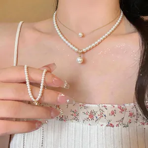Elegant detail of double-layer pearl necklace with 14k gold plating and heart pendant.