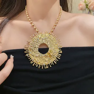 Macro view of gold-tone sunburst necklace pendant featuring rhinestone accents and a tiny bee