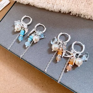 Detalle de los elegantes pendientes de plata con golondrinas, perlas y cristal
