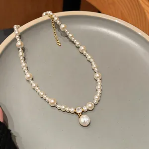 Close-up of an elegant 14k gold plated pearl necklace with a zircon pendant on a tray
