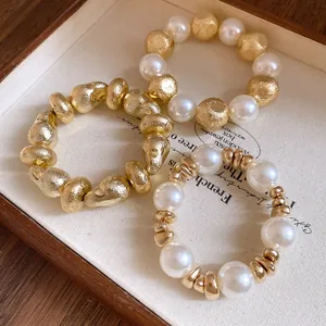 Detailed close-up showing three vintage irregular geometric and pearl beaded bracelets