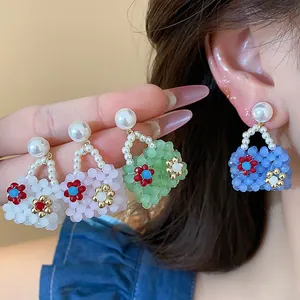 Macro detail of colorful beaded handbag earrings with pearl accents and floral designs