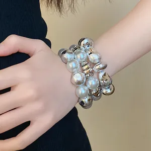 Close-up of retro irregular geometric beaded bracelet set with pearls on wrist