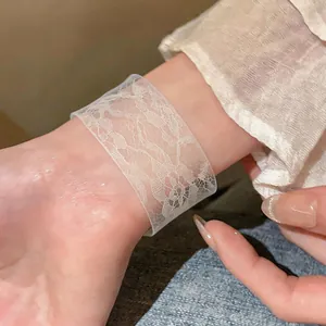 Close-up of transparent acrylic bangle featuring elegant white lace print