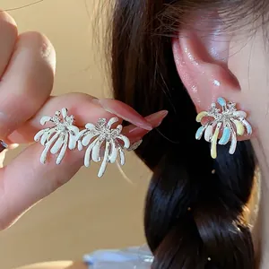 Elegant firework-shaped enamel stud earrings with zircon accents on a female ear.